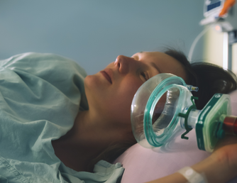 Kvinde der ligger i hospitalsseng og modtager lattergas